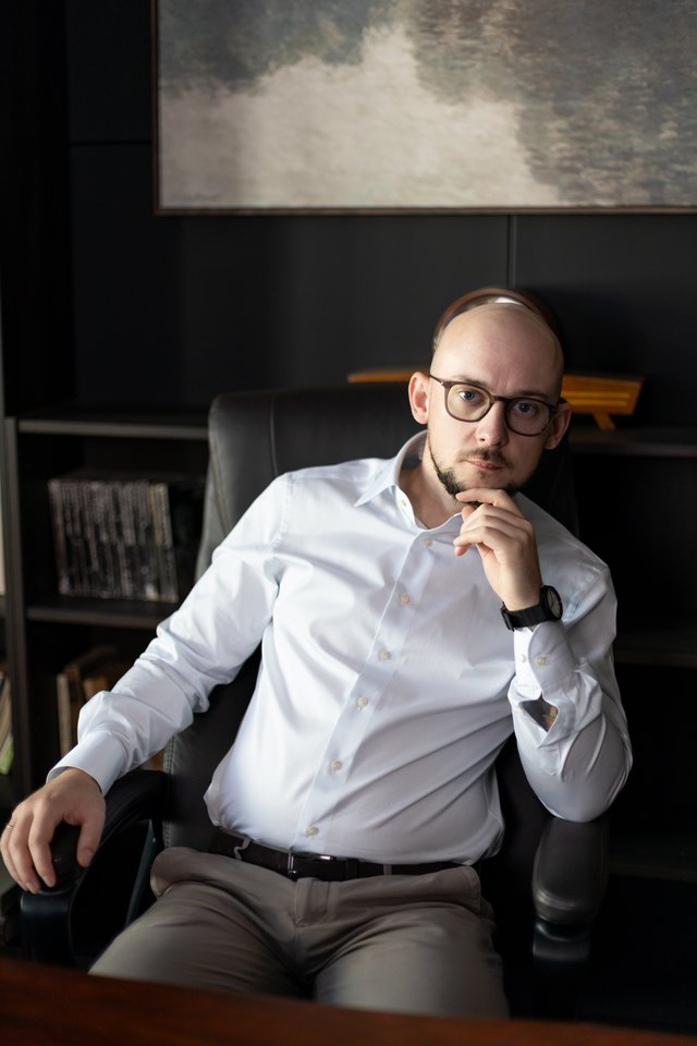 Jędrzej podczas chwili namysłu, siedzący przy stole